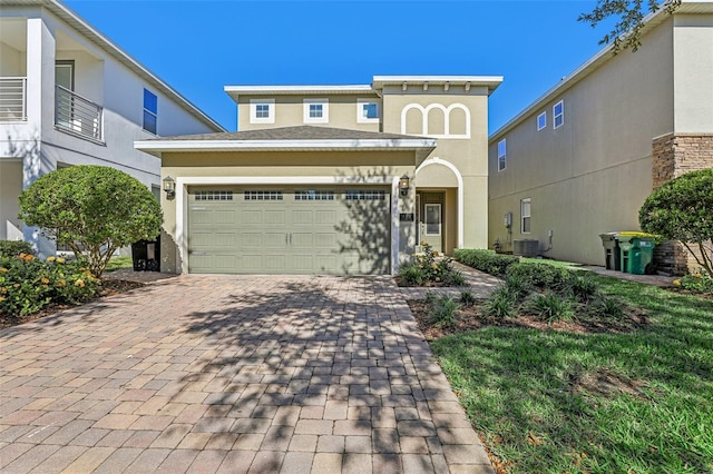 view of front of home with a garage and cooling unit