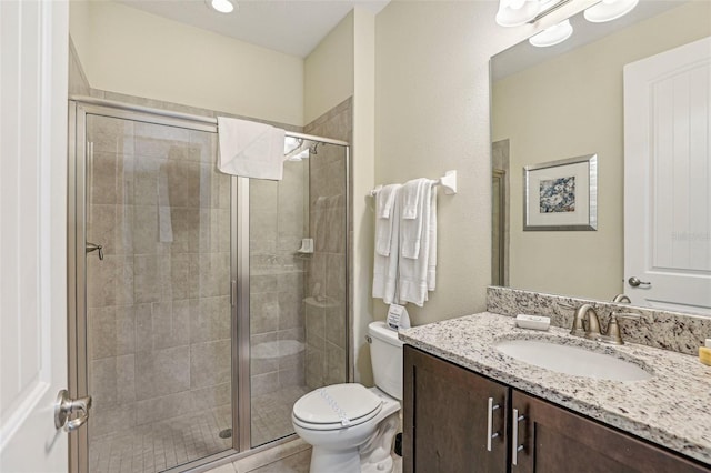 bathroom with toilet, vanity, and walk in shower