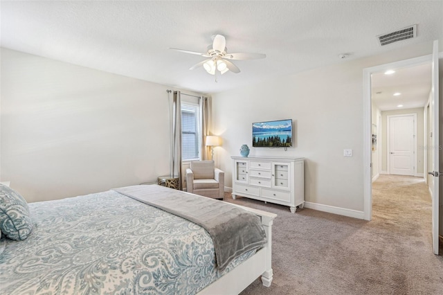 carpeted bedroom featuring ceiling fan and a textured ceiling