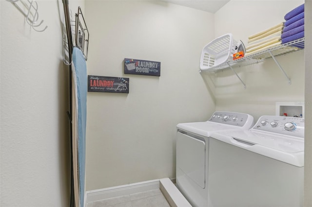 laundry room featuring washing machine and dryer and light tile patterned floors