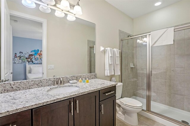 bathroom with tile patterned flooring, vanity, toilet, and an enclosed shower