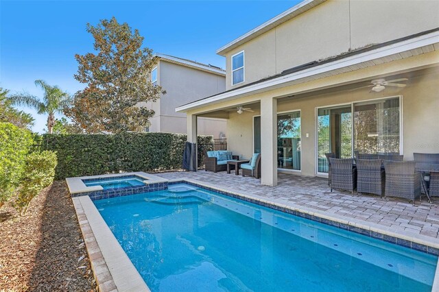 view of pool with outdoor lounge area, ceiling fan, a patio area, and an in ground hot tub