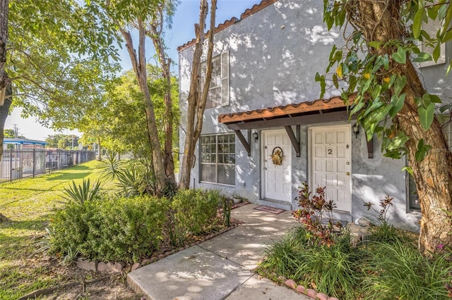 view of exterior entry featuring a yard