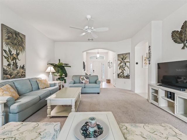 carpeted living room with ceiling fan