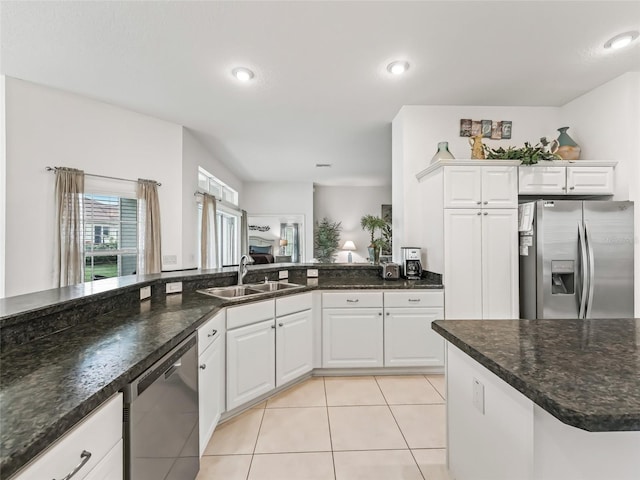 kitchen featuring white cabinetry, sink, stainless steel appliances, dark stone countertops, and light tile patterned floors