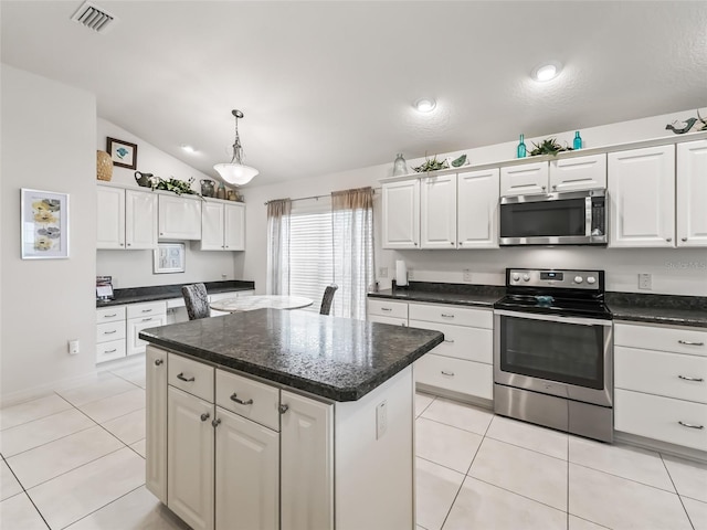 kitchen with white cabinets, stainless steel appliances, and vaulted ceiling