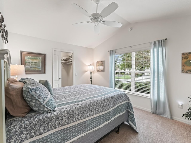 carpeted bedroom featuring ceiling fan, a closet, a spacious closet, and vaulted ceiling