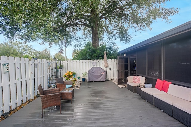 wooden terrace featuring a sunroom, an outdoor hangout area, and grilling area