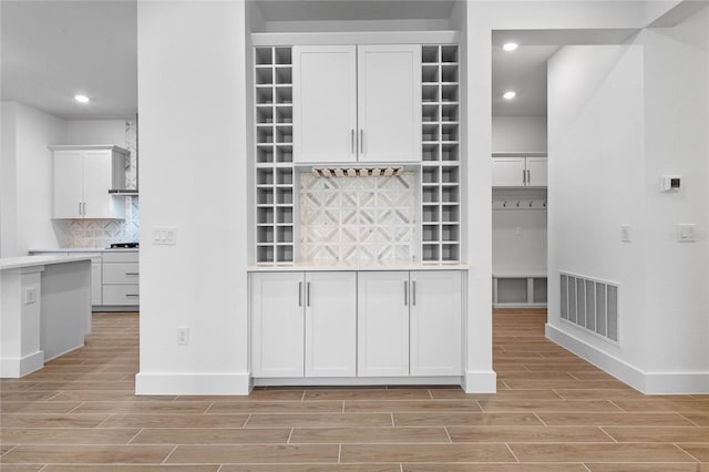 kitchen featuring decorative backsplash and white cabinets