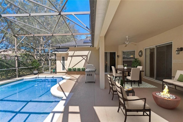 view of pool with ceiling fan, glass enclosure, a patio area, and grilling area