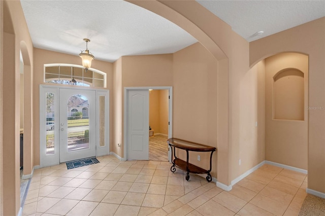 tiled entryway featuring a textured ceiling