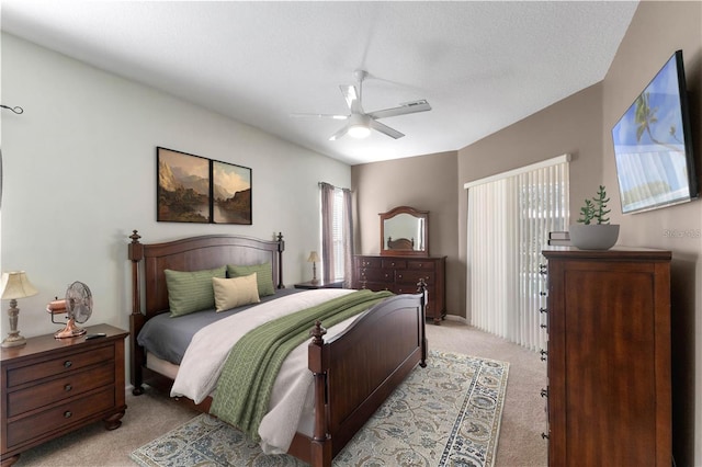 carpeted bedroom with ceiling fan and a textured ceiling