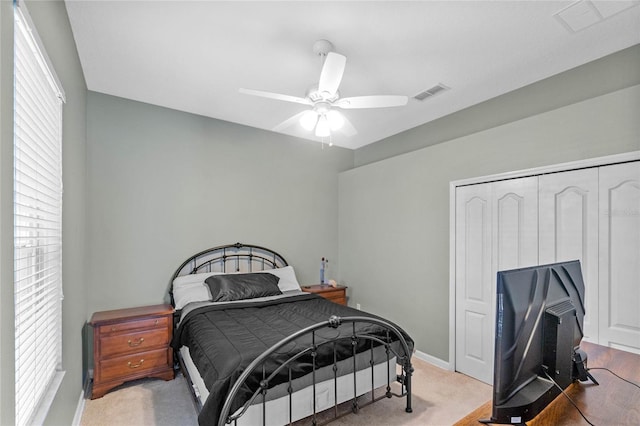 carpeted bedroom with ceiling fan and a closet