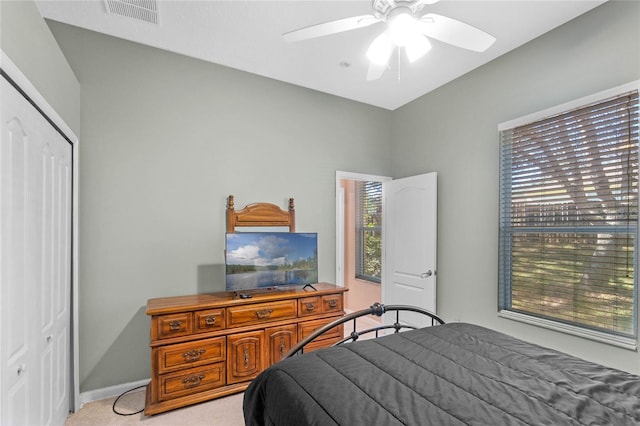 carpeted bedroom featuring ceiling fan and a closet