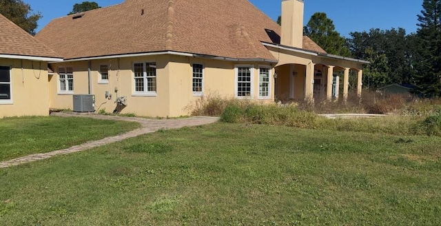 back of house with a lawn and cooling unit