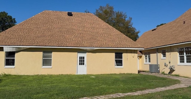 view of side of home featuring a yard and central AC