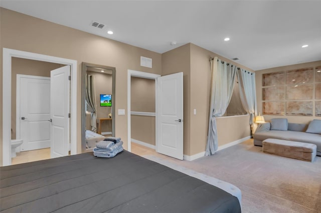 carpeted bedroom featuring ensuite bath