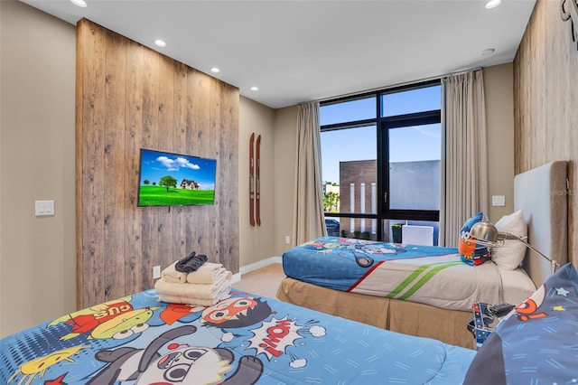 bedroom with carpet flooring and wood walls