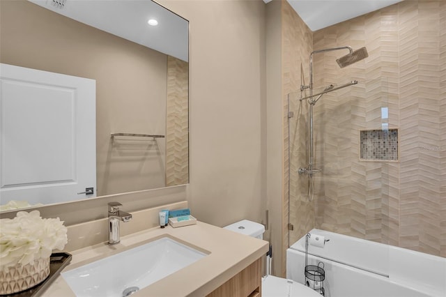 full bathroom with vanity, tiled shower / bath combo, and toilet