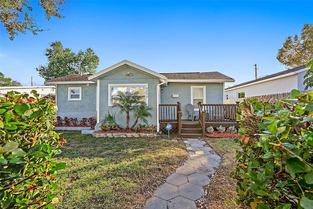 view of front of home featuring a wooden deck and a front lawn