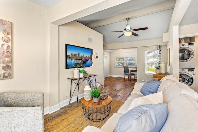 living room featuring hardwood / wood-style floors, stacked washer / drying machine, ceiling fan, and lofted ceiling with beams