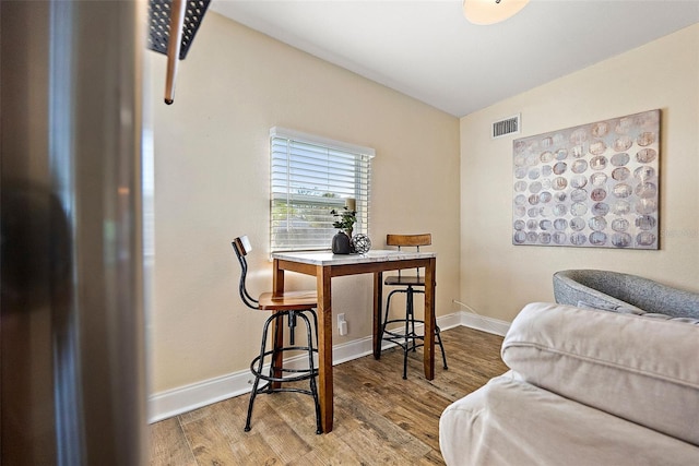 dining area with hardwood / wood-style floors and vaulted ceiling