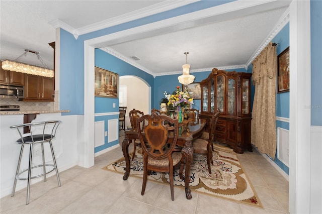 dining area with light tile patterned floors and crown molding