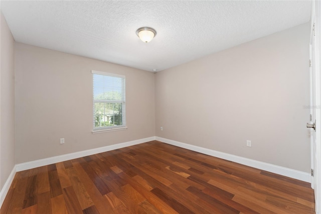 unfurnished room featuring a textured ceiling and dark wood-type flooring