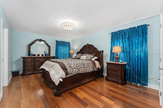 bedroom featuring wood-type flooring and a textured ceiling