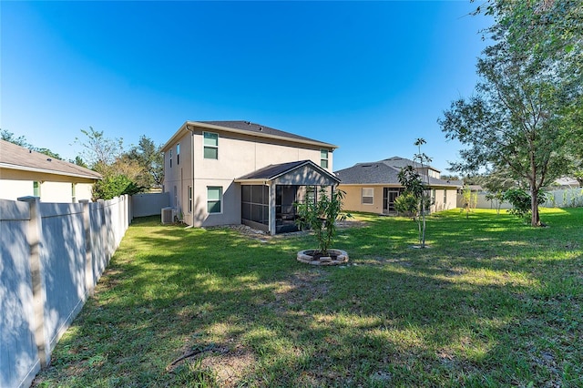 rear view of property featuring a yard and a sunroom