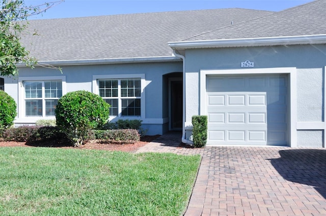 ranch-style house featuring a front yard and a garage