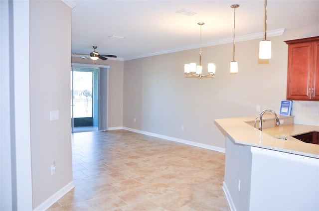 kitchen featuring crown molding, sink, hanging light fixtures, and ceiling fan with notable chandelier