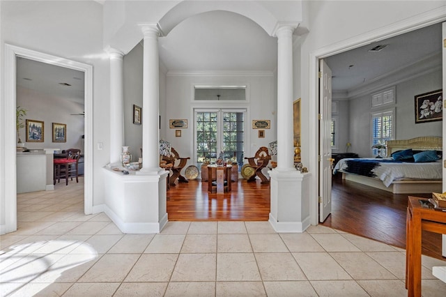 foyer with decorative columns, light hardwood / wood-style flooring, and ornamental molding