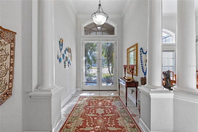 entryway with ornate columns, crown molding, light tile patterned floors, and french doors