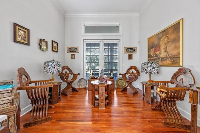 sitting room with wood-type flooring and ornamental molding