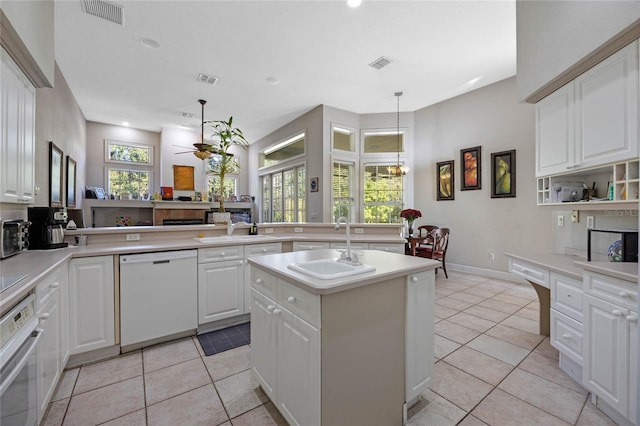 kitchen featuring a healthy amount of sunlight, white cabinetry, white appliances, and hanging light fixtures