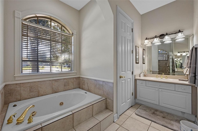 bathroom with tile patterned floors, vanity, a wealth of natural light, and tiled bath