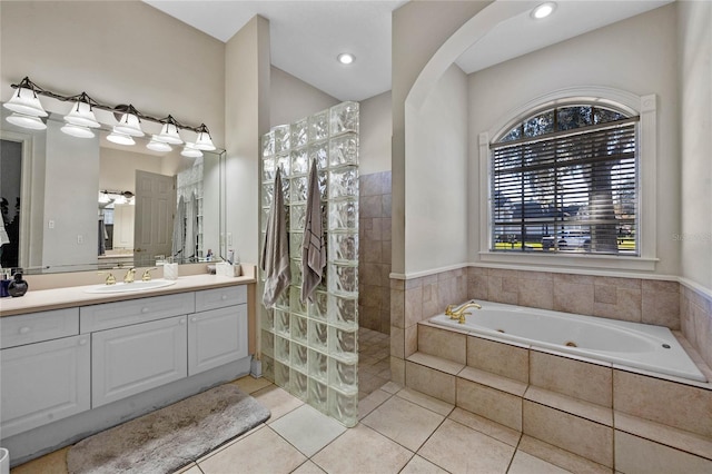 bathroom featuring tile patterned flooring, vanity, and shower with separate bathtub