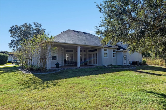 rear view of property with a yard, central AC, and a patio area