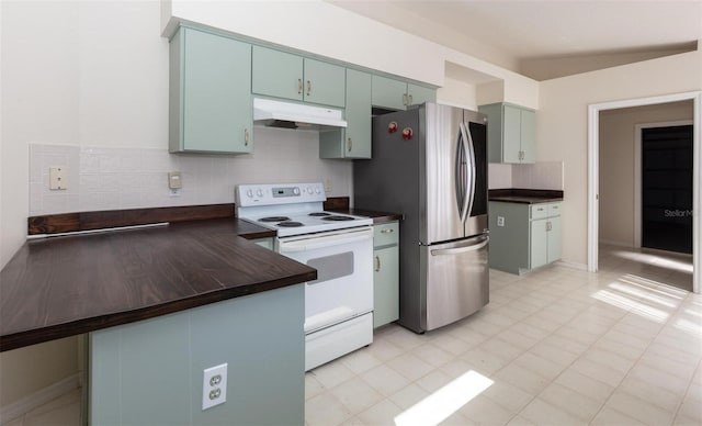 kitchen featuring decorative backsplash, white electric range, kitchen peninsula, and stainless steel refrigerator