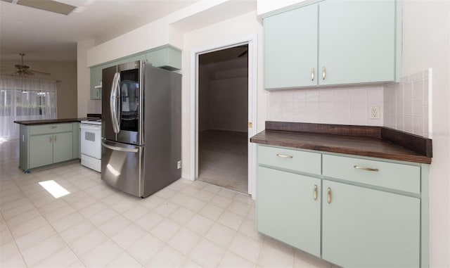 kitchen featuring ceiling fan, electric stove, stainless steel refrigerator with ice dispenser, and tasteful backsplash