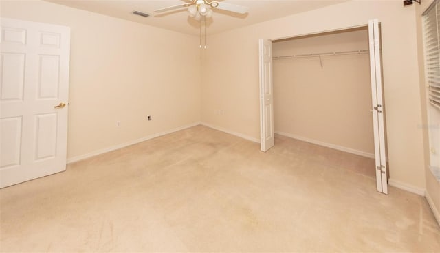 unfurnished bedroom featuring ceiling fan, a closet, and light colored carpet