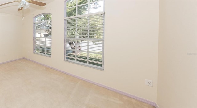 carpeted spare room with ceiling fan and lofted ceiling