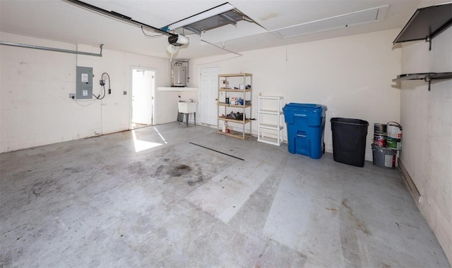 garage featuring electric panel, water heater, sink, and a garage door opener