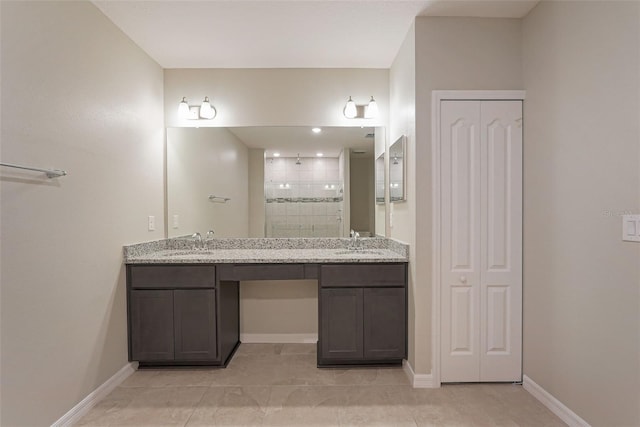 bathroom featuring a tile shower, tile patterned floors, and vanity