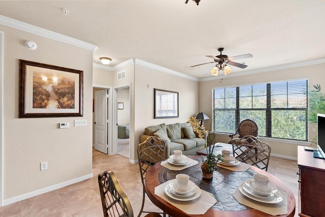 tiled dining area featuring ceiling fan and crown molding