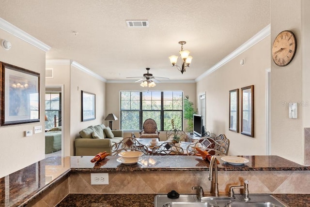 interior space featuring ceiling fan with notable chandelier, sink, and crown molding