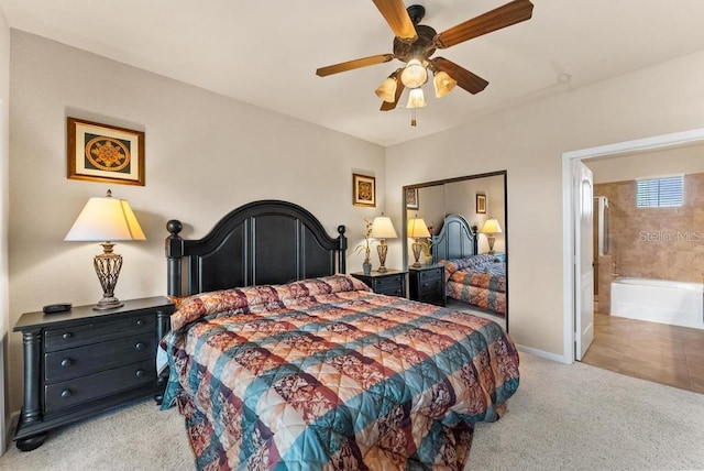 carpeted bedroom with ceiling fan, a closet, and ensuite bathroom