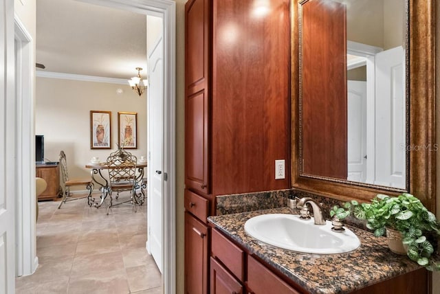 bathroom with tile patterned flooring, vanity, crown molding, and a notable chandelier