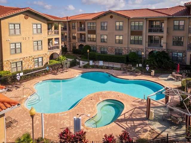 view of swimming pool with a patio and a hot tub